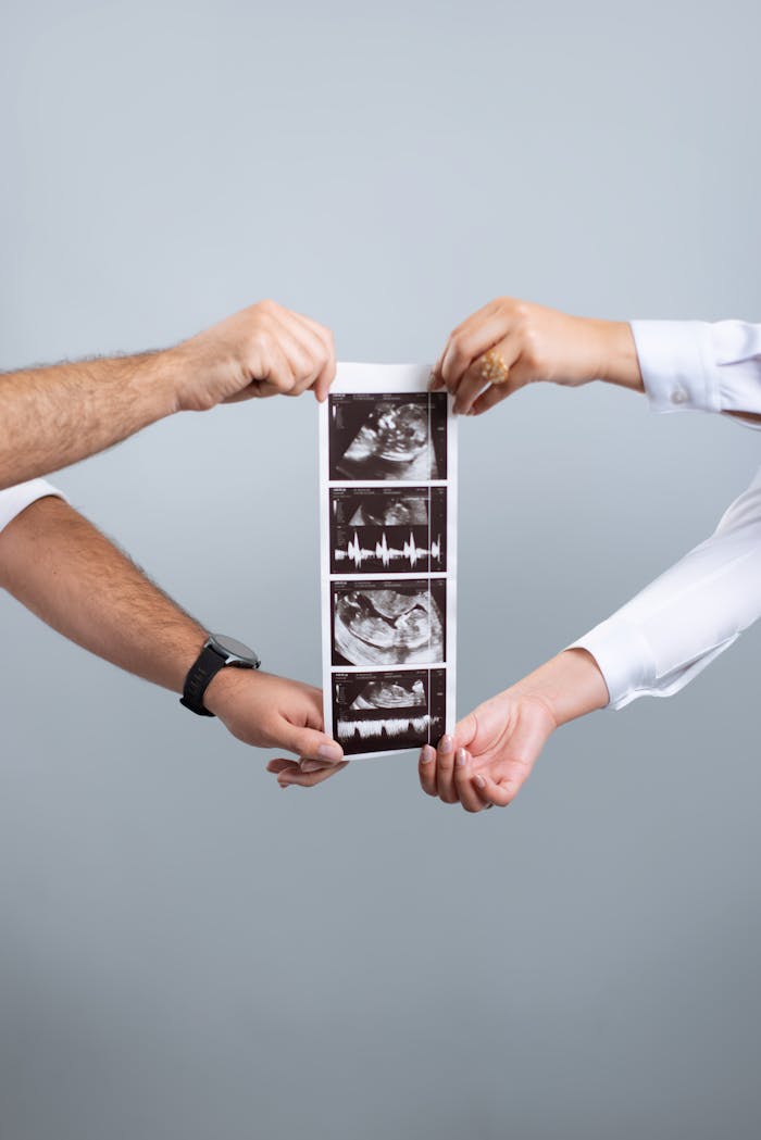 Hands of a couple holding ultrasound photos symbolizing a pregnancy moment in Caracas, Venezuela.