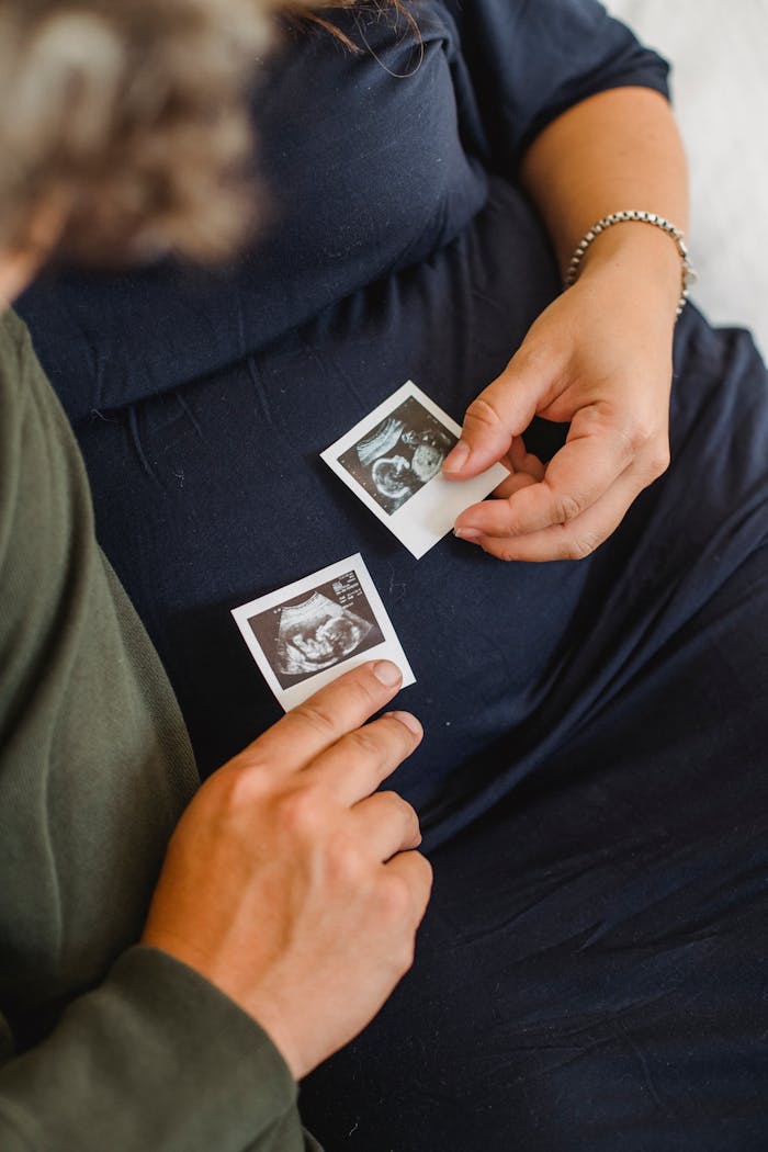 gallery-3 A pregnant couple holding ultrasound images, symbolizing anticipation and parenthood.